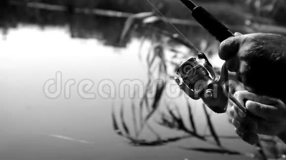 黑白镜头一个人旋转一个线圈在旋转捕捉鱼视频的预览图