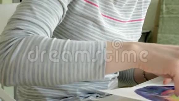 成年女性在一家家庭工作室的近景中用彩色水彩颜料作画视频的预览图