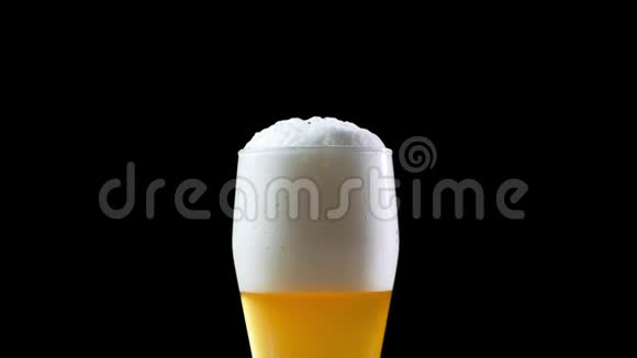 啤酒被倒入黑色背景的玻璃中啤酒倒入玻璃杯中啤酒慢移动高清框架玻璃视频的预览图