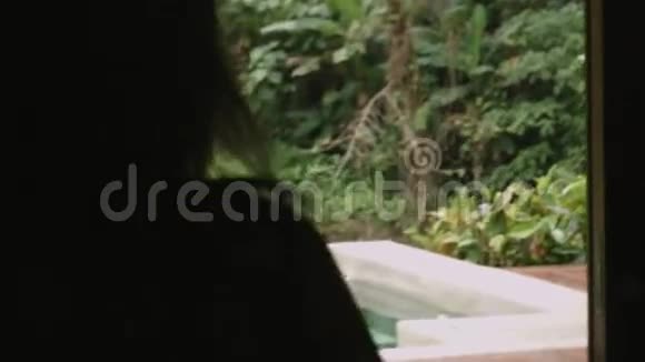 女人在露台上散步可以看到丛林视频的预览图