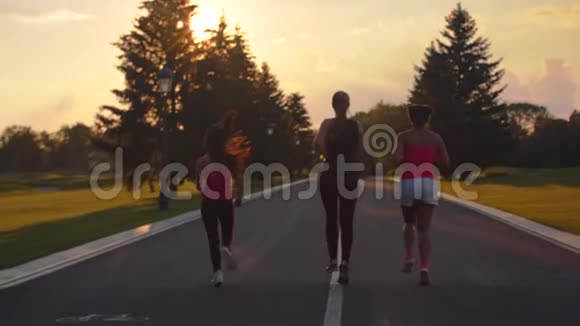 一群在日落时奔跑的女人三名健身女性跑步的后景视频的预览图