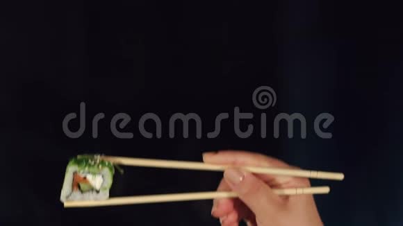 女人用筷子在黑暗中握着寿司视频的预览图