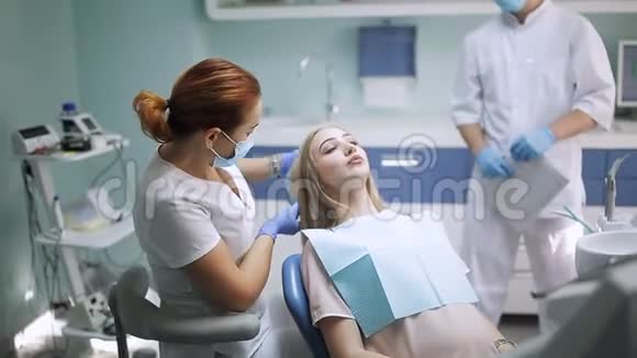 女牙医检查病人的女孩牙齿牙科诊所的牙科医生带镜子检查病人的女牙视频的预览图