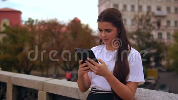 女孩在户外使用触摸屏平板电脑视频的预览图