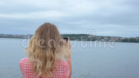 女人在湖边慢动作拍照视频的预览图