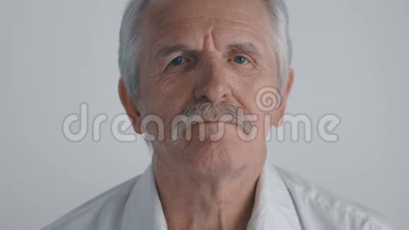 有胡子的老人的肖像看着白色背景的镜头视频的预览图