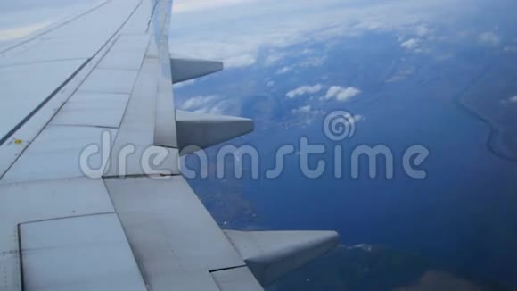 从飞机窗口可以看到飞机的翅膀风景草地田野云彩一只鸟眼睛视频的预览图