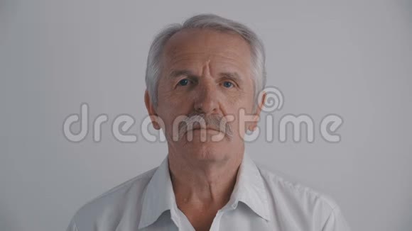 有胡子的老人的肖像看着白色背景的镜头视频的预览图
