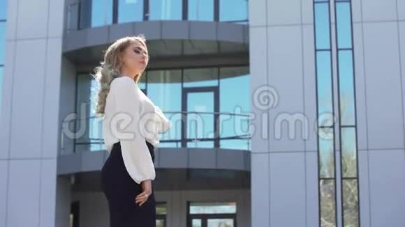 美丽的年轻商务女性溶解了办公楼背景上的头发她完成了工作享受视频的预览图