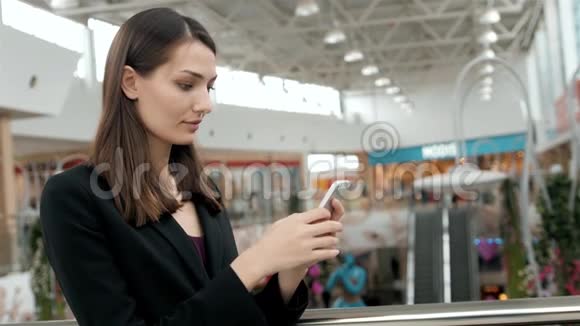 关闭商务女性在商场打电话购物中心有智能手机的漂亮女孩女商人视频的预览图