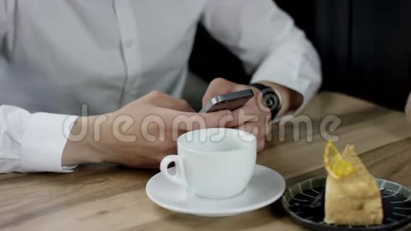 晚上一个男人在咖啡馆里用手机输入信息他双手合拢视频的预览图