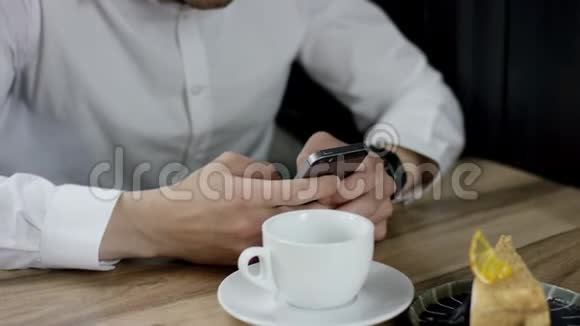 晚上一个男人在咖啡馆里用手机输入信息他双手合拢视频的预览图