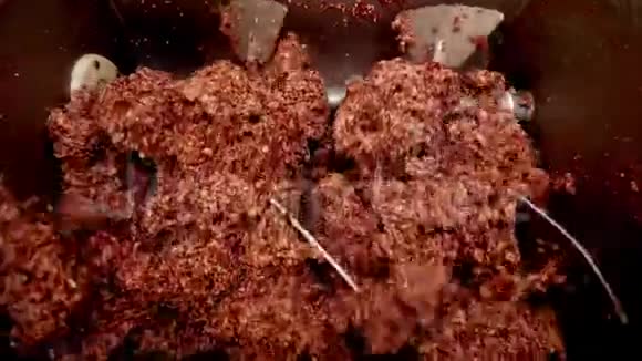 在一家肉类工厂的特写镜头上在一个巨大的绞肉机上加工猪油或肉末视频的预览图