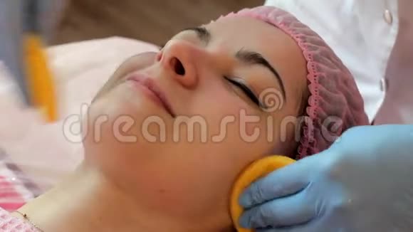 美丽的女人被剥落的明亮海绵洗掉了在手术过程中微笑视频的预览图