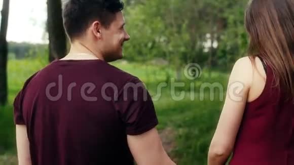 回到浪漫的年轻夫妇在森林里散步牵手交谈和微笑斯泰迪卡姆视频的预览图