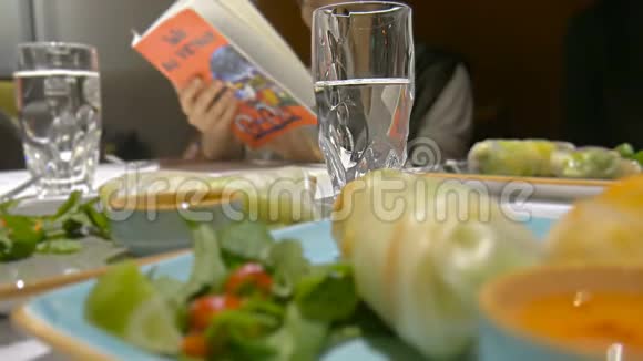越南春卷配桌玻璃水女性阅读菜单视频的预览图