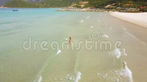 穿比基尼的年轻女子穿着绿松石的夏季海滩背景在透明和清澈的水里看到女人视频的预览图