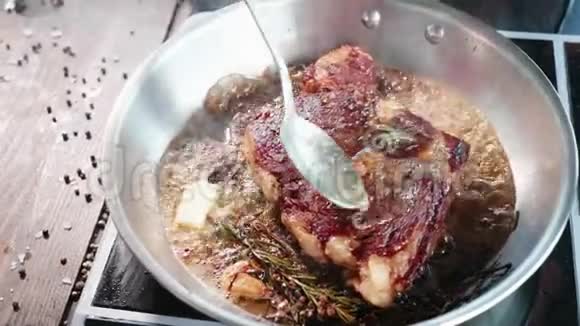 肉牛排是用油和油脂在煎锅上煎特写慢动作视频的预览图