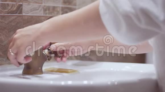 漂亮的女孩用牙刷在浴室里刷牙头上戴着毛巾自理的概念视频的预览图