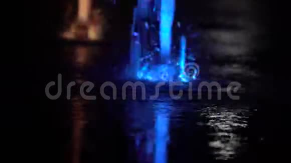 小孩玩光喷泉夜晚五颜六色的飞溅滴视频的预览图
