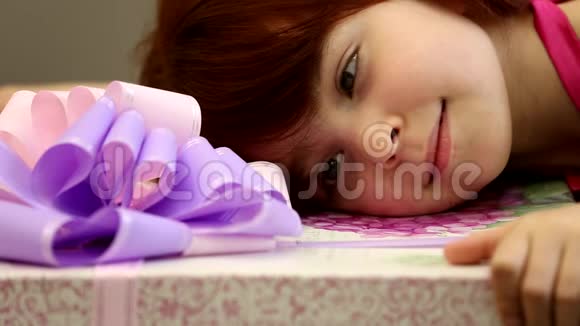 快乐的小可爱的女孩抱着巨大的礼物盒粉红色紫罗兰色的紫色丝带蝴蝶结近距离欣赏视频的预览图