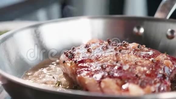 肉牛排是用油和油脂在煎锅上煎特写慢动作视频的预览图