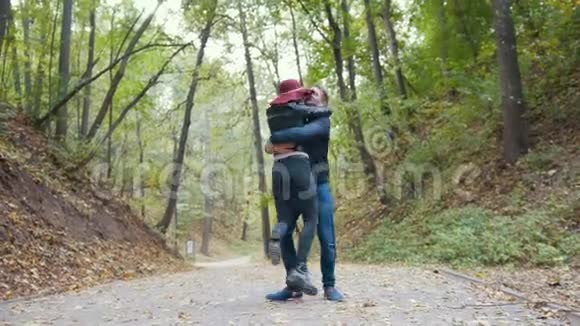 秋天公园黄叶间的浪漫情侣视频的预览图