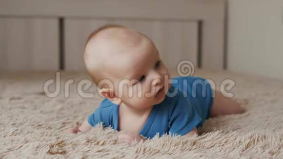 快乐的新生儿躺在家里的床上卧室里的男婴肖像小男孩视频的预览图