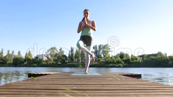 女人在湖边做瑜伽在大自然中放松视频的预览图
