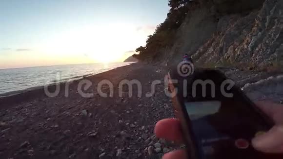 在沙滩上看日落的电话视频的预览图