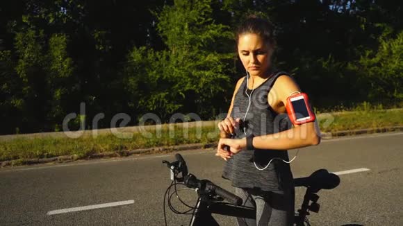女人骑着一辆带智能手表心率监视器的自行车智能手表的概念视频的预览图