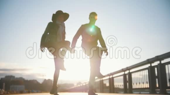 快乐的一对情侣在户外玩得很开心男人和女人在日落时跳舞动作缓慢视频的预览图