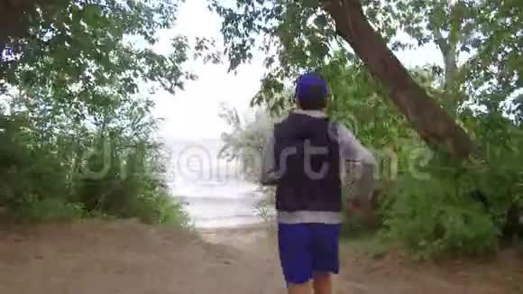 男孩奔跑炎热的日子给大自然浇水视频的预览图