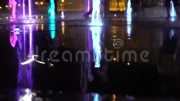 小孩玩光喷泉夜晚五颜六色的飞溅滴视频的预览图