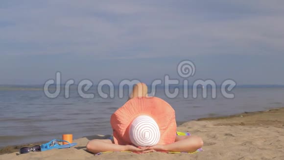 美丽的女人躺在海滩上做热身腿视频的预览图