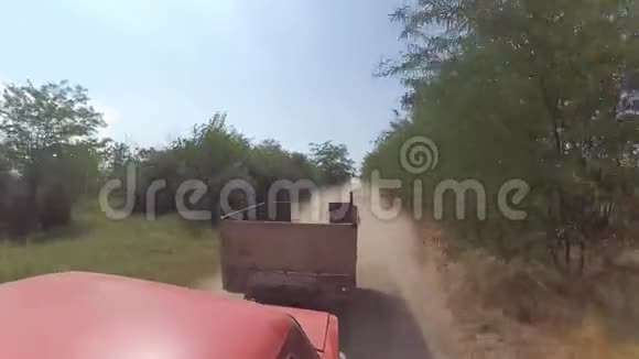 一辆汽车在土路上旅行车轮上扬起的尘土视频的预览图