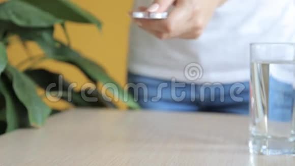 从桌子上拿药丸的女人视频的预览图