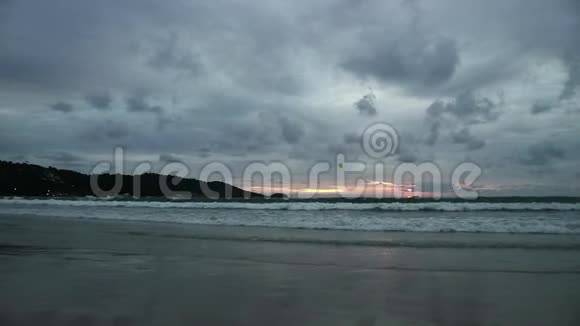 日落时的海景倒映在潮湿的沙滩上海浪涌来有伞的摩托艇视频的预览图