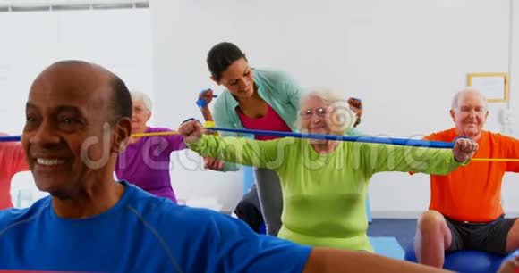 高加索女教练在4k健身工作室训练高级女性锻炼的正面视角视频的预览图