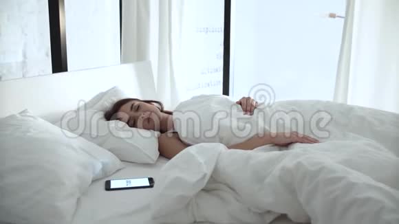 闹钟在电话里睡在床上的女人视频的预览图