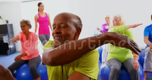 高加索女培训师在4k健身工作室训练老年人锻炼的正面视角视频的预览图