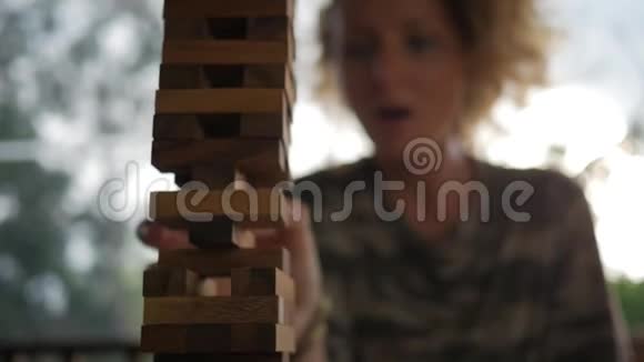 年轻的快乐女孩用手把木块贴在塔顶上高清慢动作桌游视频视频的预览图