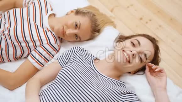 两个十几岁的女孩躺在舒适的房间里享受乐趣视频的预览图