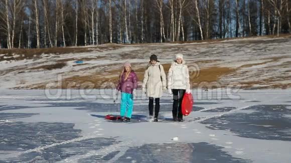 一家人在冰冻的湖面上散步视频的预览图