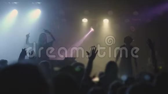 两个漂亮的年轻女人DJ在夜总会的混合控制台上播放音乐在无法辨认的人的背景下视频的预览图