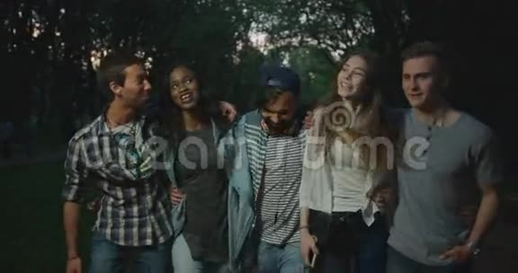 这五位多文化的时髦朋友在傍晚散步时笑着拥抱在一起视频的预览图
