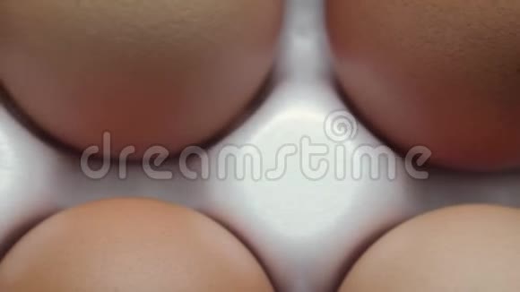 在白色托盘中产卵的十个橙壳蛋的俯视图视频的预览图