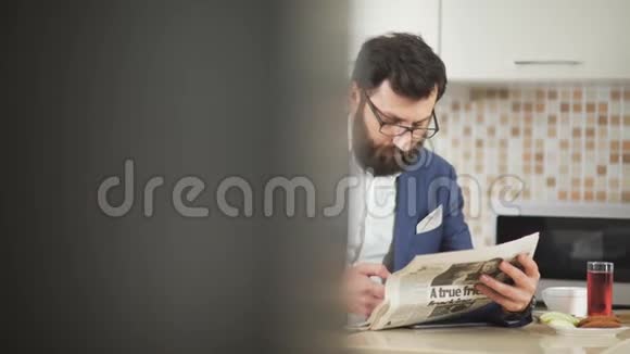 银行家在上班前喝着早咖啡阅读新鲜的晨报视频的预览图