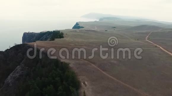 巨大的草原沙石山悬崖沙漠峡谷松树在贝加尔湖海滩海岸线4k空中无人机海景视频的预览图