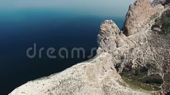 美丽的石岩山悬崖在贝加尔湖平静的深蓝水在4k无人机空中海景天际线晴天视频的预览图